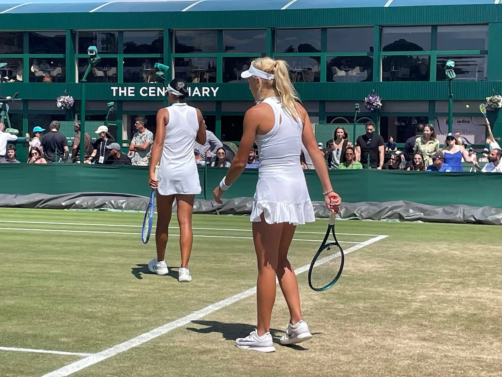 Vận động viên thi đấu tại Wimbledon trong trang phục trắng bắt buộc, biểu tượng của sự thanh lịch và văn hóa thể thao.