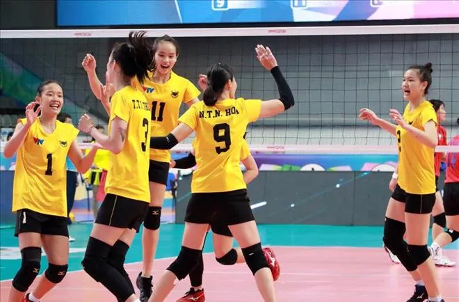 Trận đấu bóng chuyền trong nhà đang diễn ra với bảng điểm hiển thị kết quả