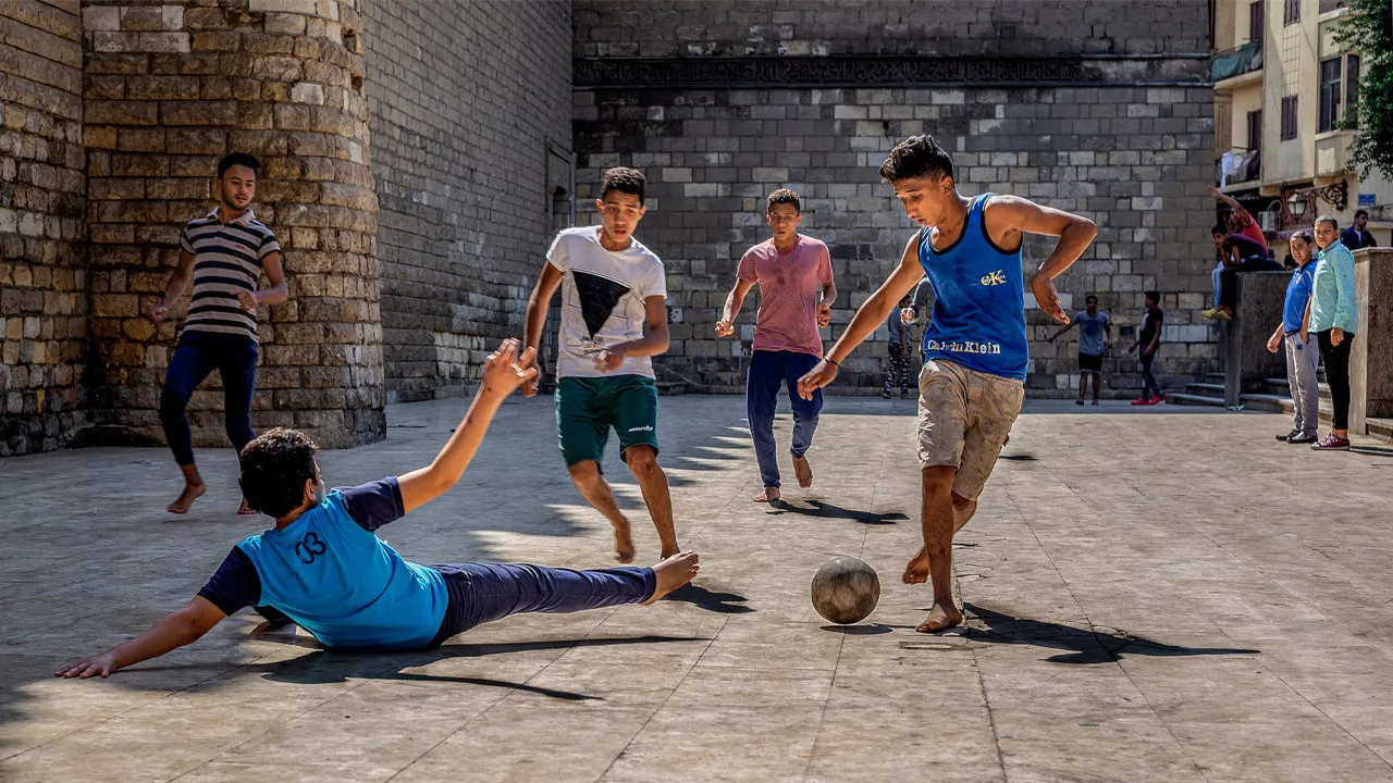 Cảnh chơi bóng đá không chuyên, thể hiện tính dễ tiếp cận của đá bóng là gì