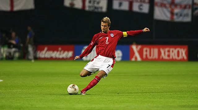 Cầu thủ bóng đá đang thực hiện cú sút mạnh mẽ, bóng bay về phía khung thành đối phương