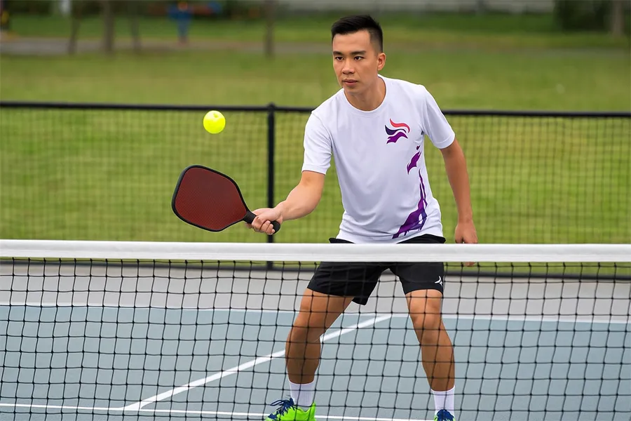 Người chơi Pickleball chuẩn bị tư thế đánh trả bóng, một phần quan trọng trong Hướng Dẫn Chiến Thuật Giao Bóng – Lên Lưới Hiệu Quả Cho Người Chơi Trung Cấp