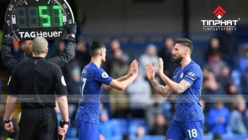 Cầu thủ dự bị khởi động bên ngoài đường pitch, chuẩn bị vào sân thi đấu