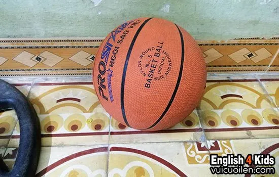 Quả bóng rổ màu cam và lưới rổ trên sân đấu