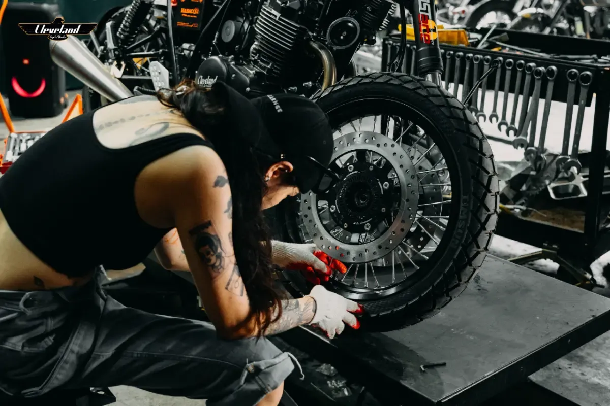 Hình ảnh cận cảnh một người đang kiểm tra lốp xe và phanh đĩa trước khi khởi hành